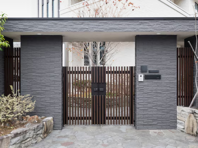 Technician cleaning and maintaining safety sensors for gates to ensure reliability