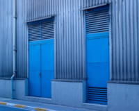 Vision Z-Wave Outdoor Siren mounted on factory exterior wall - industrial alarm siren