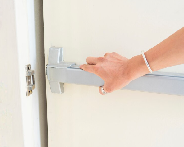 A panic bar releases the mechanical latch when pressure is applied across the bar.